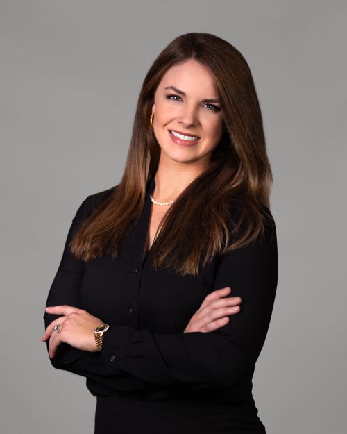 Professional headshot of a woman in a navy blouse