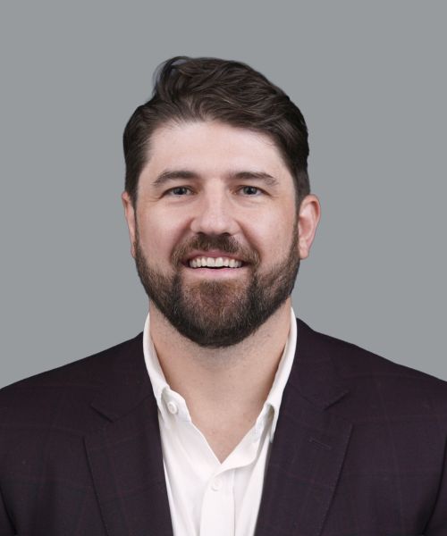 Professional headshot of a young man in business attire.