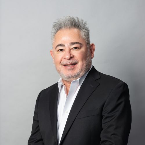 Professional headshot of a businessman in a dark suit with a light blue shirt.