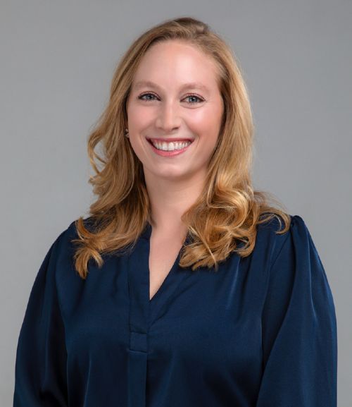 Professional headshot of a woman in a navy blouse