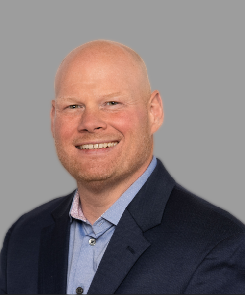 Professional headshot of a woman with long brown hair in a black long-sleeved top.