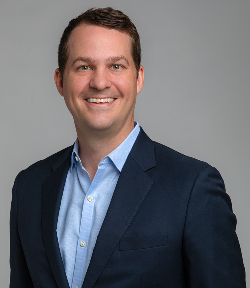Professional portrait of a business executive in a dark blazer