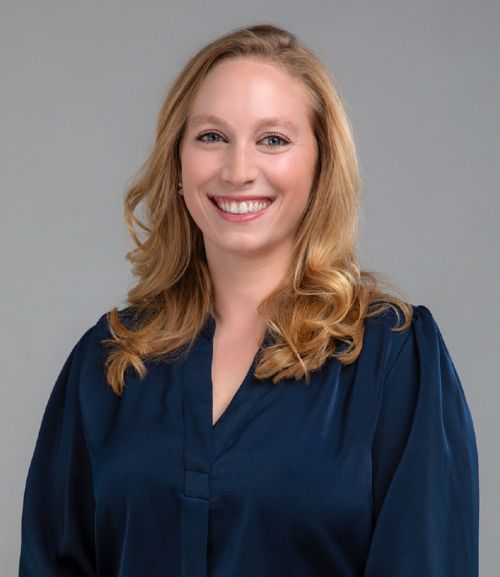Professional headshot of a woman in a navy blouse